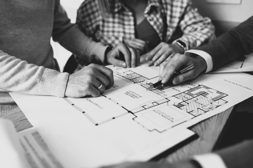 l'immagine rappresenta delle persone sedute ad un tavolo che fanno delle donazioni immobiliari