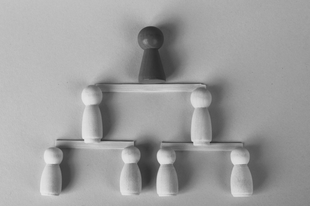 A black-and-white image depicting, using game pieces, a line of heirs to the estate of a progenitor. The image serves as an illustration for the article on the case study of how Antonello Law Firm handled the estate of two foreign nationals who purchased a property in Italy.